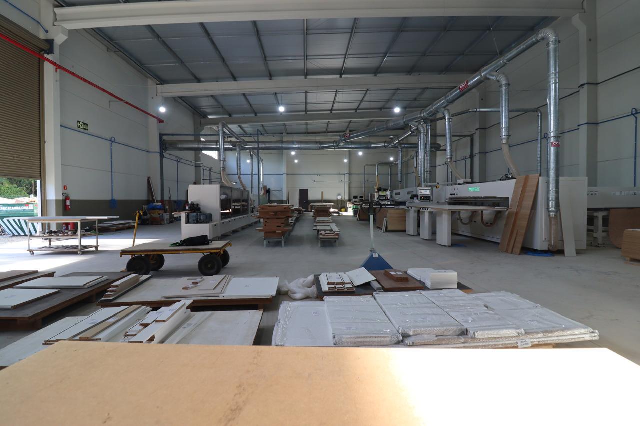 Vista geral da indústria Movel-Go com maquinário industrial e chapas em processo